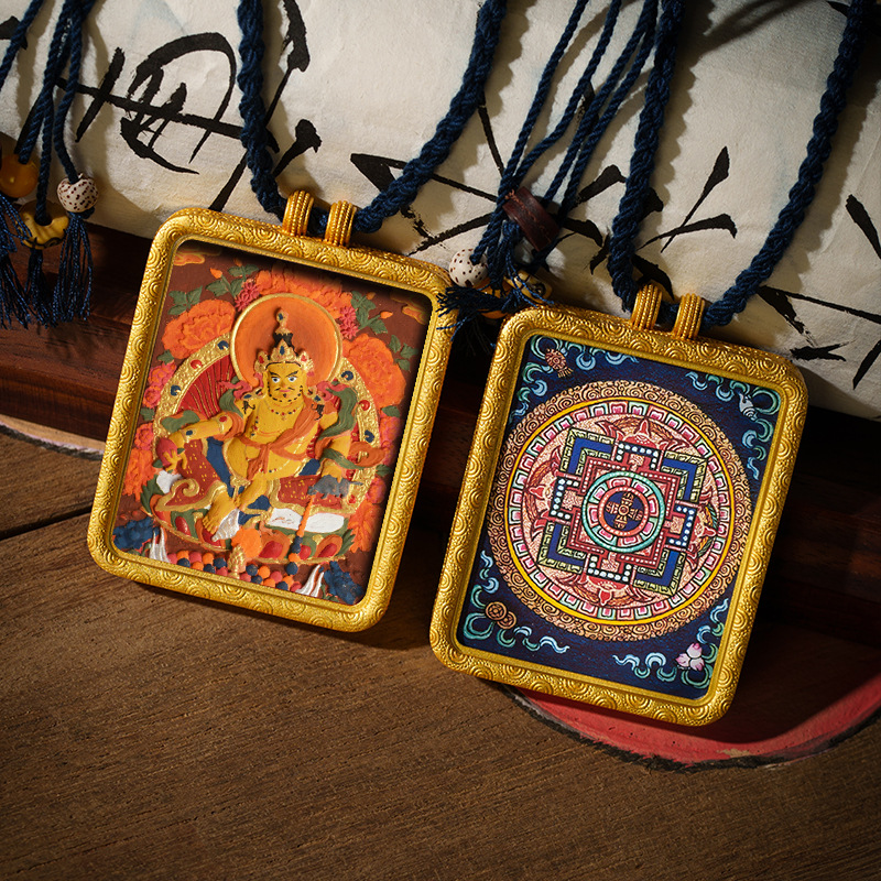 Two ornate pendants on strings with intricate designs, one featuring a colorful figure and the other a geometric pattern.