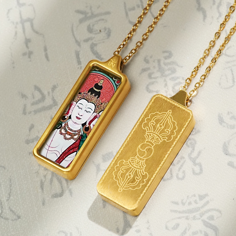 Gold pendant with a religious figure design on a textured gray background