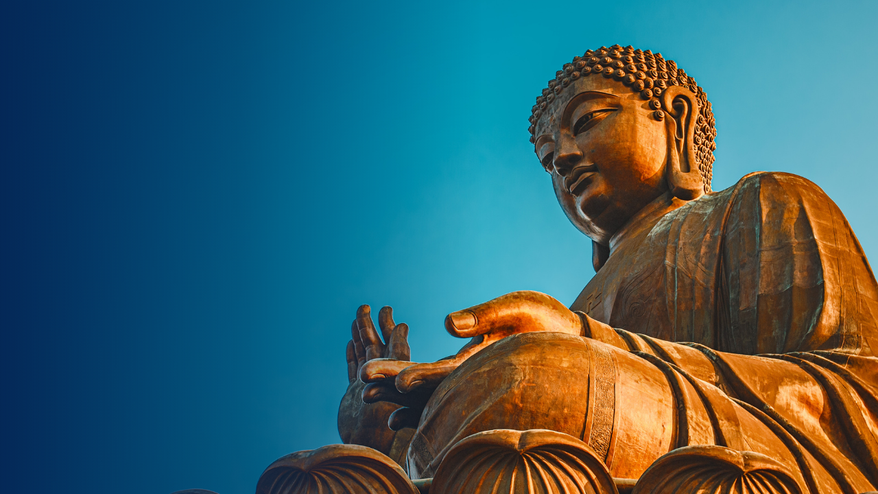 Bronze Buddha statue against a clear blue sky